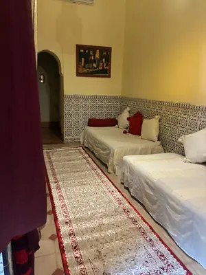 a room with two beds and a rug at Riad El Filali in Marrakech