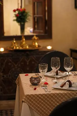 a table with a white table cloth and wine glasses at Riad Zayane in Marrakech