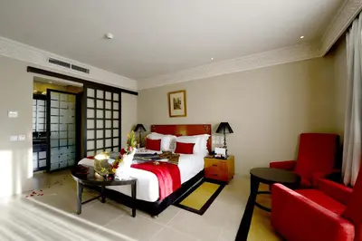 a bedroom with a large bed and a red couch at Adam Park Marrakech Hotel & Spa in Marrakech