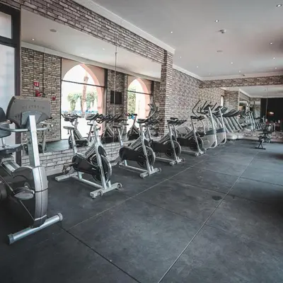 a gym with a row of treadmills and ellipticals at Adam Park Marrakech Hotel & Spa in Marrakech