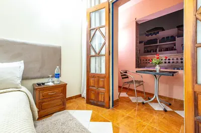 a bedroom with a bed and a table with a wine cellar at Hotel Oudaya & Spa in Marrakech