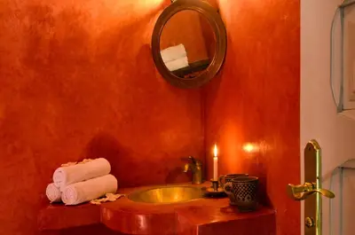 a bathroom with a sink and a mirror and towels at Riad Vert in Marrakech