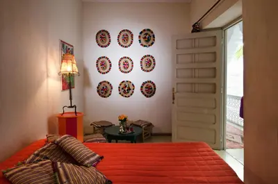 a bedroom with a red bed and plates on the wall at Riad Vert in Marrakech