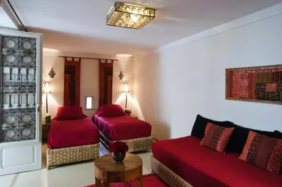 a hotel room with two beds and a couch at Riad Vert in Marrakech