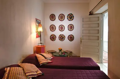 a bedroom with two beds and plates on the wall at Riad Vert in Marrakech