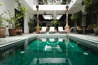 an indoor pool with chairs and a swimming pool at The Central House Marrakech Medina in Marrakech