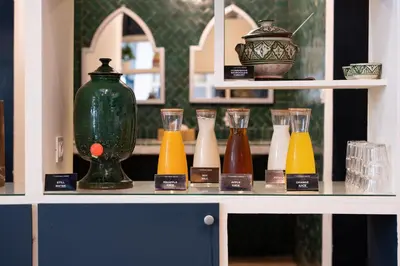 a shelf with different colored glass vases on it at The Central House Marrakech Medina in Marrakech