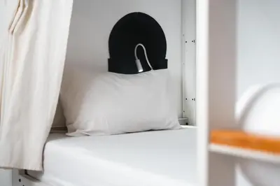 a bed with a pillow with a black head board at The Central House Marrakech Medina in Marrakech