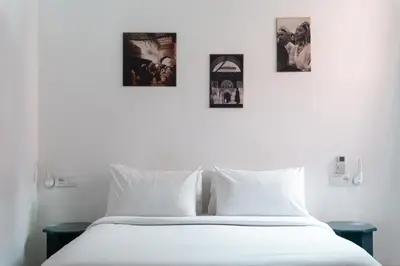 a white bed with four pictures on the wall at The Central House Marrakech Medina in Marrakech