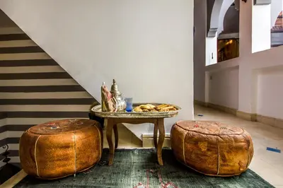a table and two ottomans with a tray of food on it at Riad Dar Azul in Marrakech