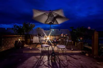 a patio with a table and chairs and an umbrella at Riad Dar Azul in Marrakech