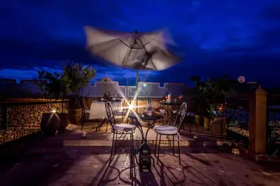 a patio with a table and chairs and an umbrella at Riad Dar Azul in Marrakech