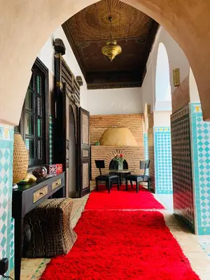 a living room with a red rug and a table at Riad Dar Azul in Marrakech