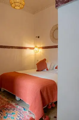 a bedroom with a bed with a red blanket at Riad Le Marocain in Marrakech