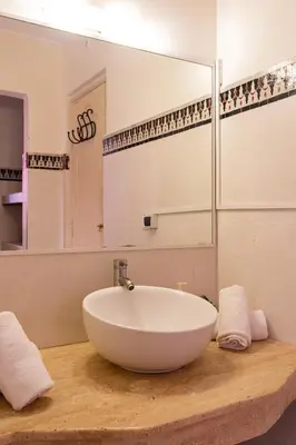 a bathroom with a large white bowl sink on a wooden counter at Riad Le Marocain in Marrakech