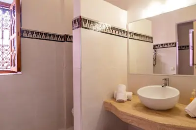 a bathroom with a white sink and a shower at Riad Le Marocain in Marrakech
