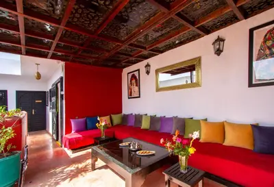 a living room with a red couch and colorful pillows at Ryad Amiran & Spa in Marrakech