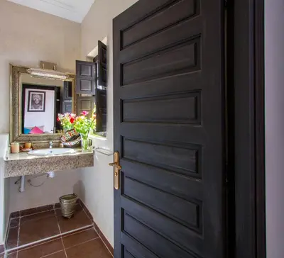 a black door in a bathroom with a sink at Ryad Amiran & Spa in Marrakech