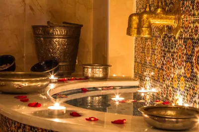 a bath tub with candles and a fountain with lights at Ryad Amiran & Spa in Marrakech