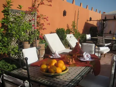 a table with a bowl of fruit on a patio at Riad Alida in Marrakech