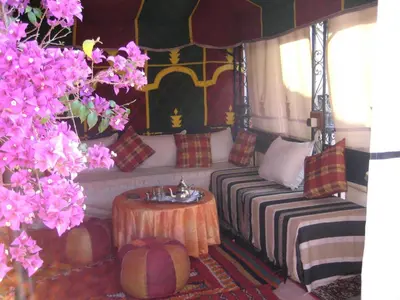 a room with a bed and a table and flowers at Riad Alida in Marrakech