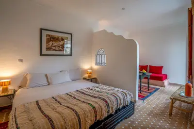 a bedroom with a bed and a red couch at Riad Nora in Marrakech