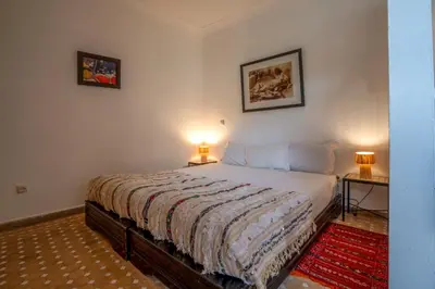 a bedroom with a bed and two lamps on two tables at Riad Nora in Marrakech