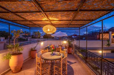 a patio with a table and chairs on a balcony at Riad Nora in Marrakech