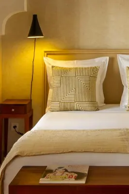 a hotel room with a bed with a book on a table at Riad Bab 54 in Marrakech