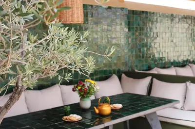 a table with a tea kettle and flowers on it at Riad Bab 54 in Marrakech