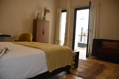 a bedroom with a bed and a chair and a window at Riad Bab 54 in Marrakech