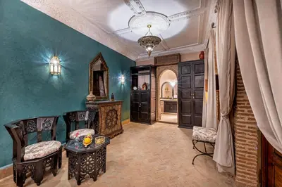 a room with two chairs and a table and some doors at Maïpa Boutique Riad in Marrakech