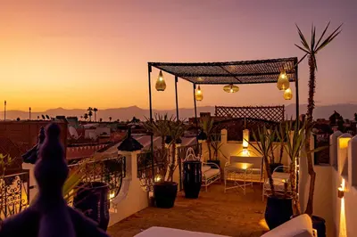 a person standing on a balcony looking at the sunset at Maïpa Boutique Riad in Marrakech