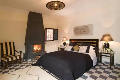 a bedroom with a bed and a fireplace at Riad Elizabeth in Marrakech