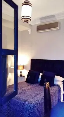 a bedroom with a bed with a large mirror at Riad Elizabeth in Marrakech