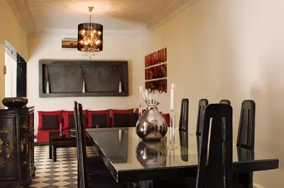 a dining room with a glass table and red chairs at Riad Elizabeth in Marrakech