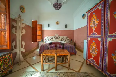 a bedroom with a bed and a table in it at Riad Euphorbe in Marrakech