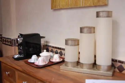 a counter with a coffee maker and two pillar candles at Riad Le Plein Sud in Marrakech