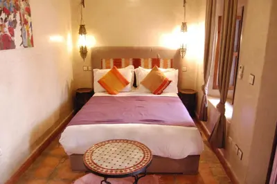 a bedroom with a large bed with colorful pillows at Riad Le Plein Sud in Marrakech