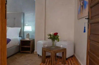 a bedroom with a vase of flowers on a table at Riad Le Plein Sud in Marrakech