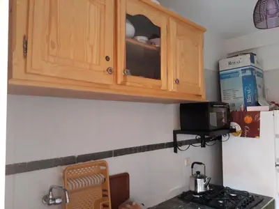 a kitchen with wooden cabinets and a stove top oven at Relaxation apartment in Marrakech