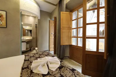 a bedroom with a bed and a large window at Riad L'Etoile D'Orient in Marrakech