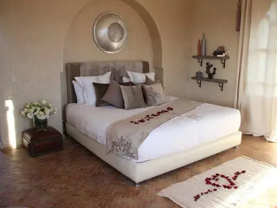 a bedroom with a large white bed with roses on it at Palais Lona in Marrakech
