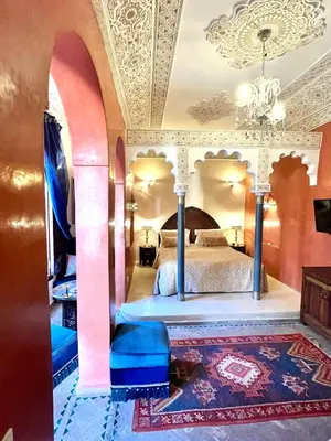 a bedroom with a bed and a chandelier at Riad Fatinat Marrakech in Marrakech