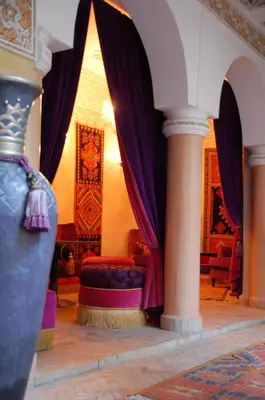 a bedroom with purple curtains and a bed in a room at Riad Fatinat Marrakech in Marrakech