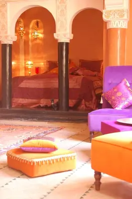 a room with a bed and a couch and chairs at Riad Fatinat Marrakech in Marrakech