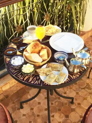 a table with a tray of food and bread on it at Riad Fatinat Marrakech in Marrakech