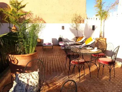 a patio with a table and chairs and plants at Riad Fatinat Marrakech in Marrakech
