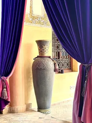 a large vase sitting in front of a curtain at Riad Fatinat Marrakech in Marrakech