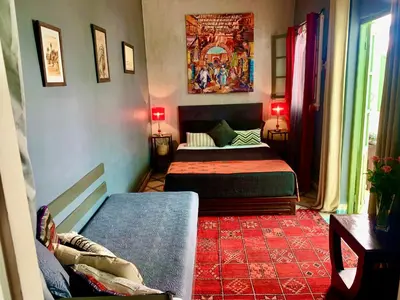 a bedroom with two beds and a red rug at Dar Zemrane in Marrakech